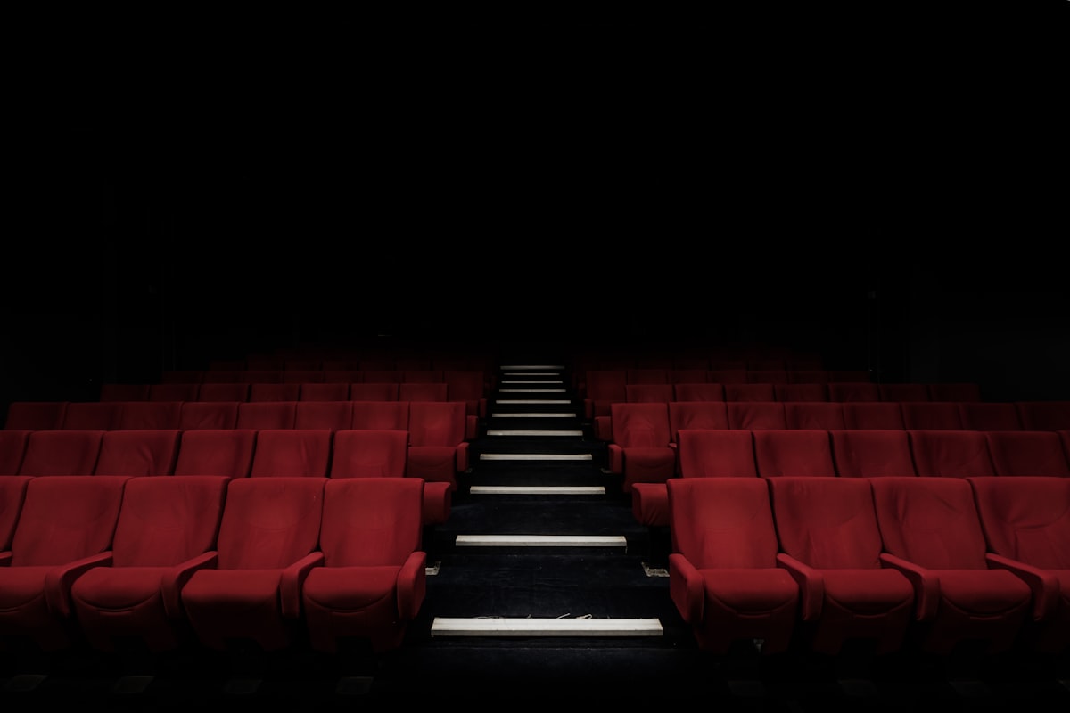A dark movie theater with light from the screen